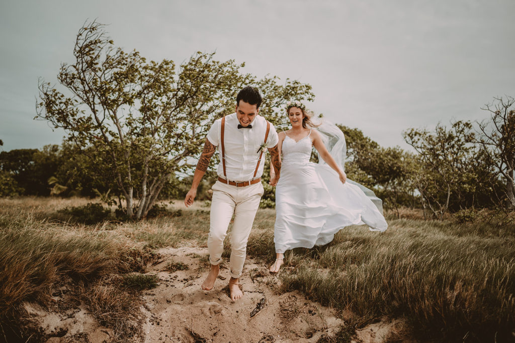 bride and groom running in the wild after their beach elopement