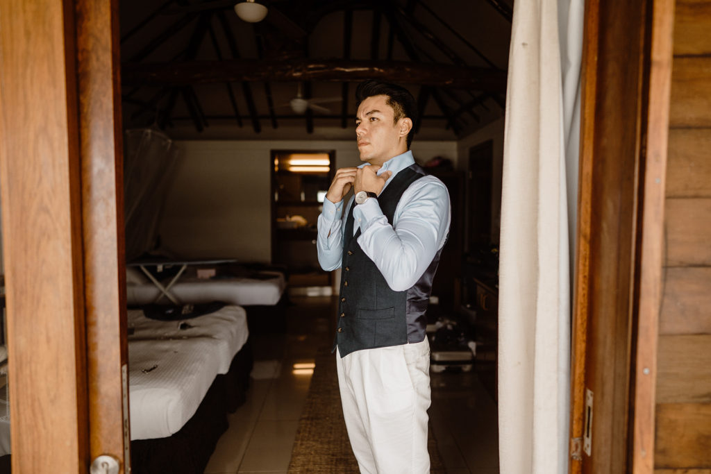 groom getting ready for his beach elopement