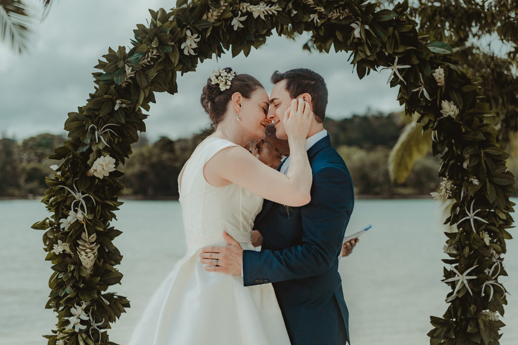 Couple standing by wedding arch on Erakor Island