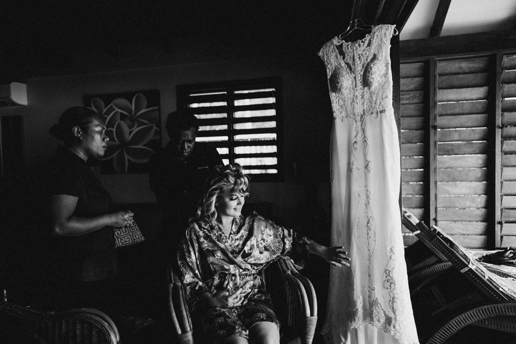 Bride getting ready with her wedding dress hanging in the honeymoon suit on Erakor Island 