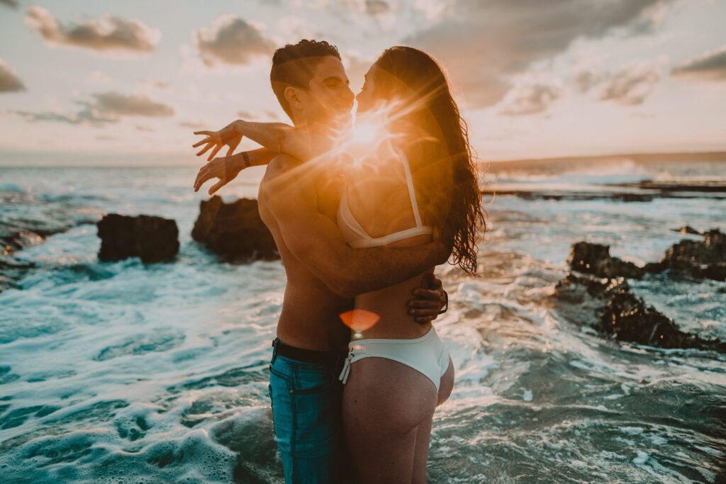 Straight couple at the beach, in swimwear, hugging with the sun setting behind them during their pre-wedding photoshoot in Vanuatu 